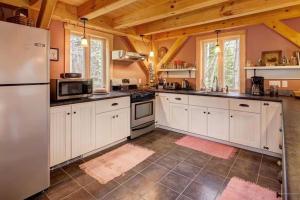 eine Küche mit weißen Geräten und Holzdecken in der Unterkunft Acadia Lobsterman's Secret Cottage in Lamoine Beach + 8 Fotos