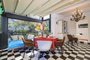 a dining room with a table and chairs at Jacaranda Cottage in Malinska