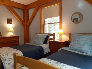 ein Schlafzimmer mit zwei Betten und einem Fenster in der Unterkunft Acadia Lobsterman's Secret Cottage in Lamoine Beach