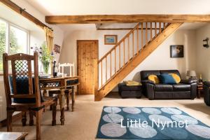 sala de estar con escalera y mesa en The Old Rectory Cottages - Six Luxurious Cottages Set In Grounds With Indoor Pool, en Kings Nympton
