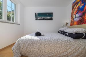a bedroom with a bed and a painting on the wall at Jacaranda Cottage in Malinska +31 photos