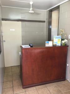 a reception desk in a room with a door at Plantation Park Motor Inn in Ayr