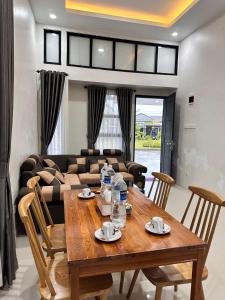 a living room with a wooden table and a couch at Livi Guest House in Sekupang