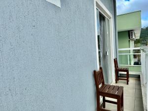 two chairs sitting on the porch of a house at Residencial Leão 355 - Apartamentos econômicos - 15min a pé da Praia de Bombas in Bombinhas