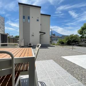 un patio con una mesa de madera y un edificio en Villa ANOTONA No 1, en Fujikawaguchiko