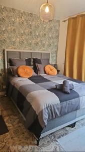 a bedroom with a bed with orange pillows on it at Lavenir in Clichy +5 photos