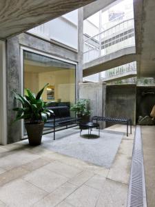 a lobby with benches and plants in a building at Oporto Serviced Apartments - Miragaia II in Porto