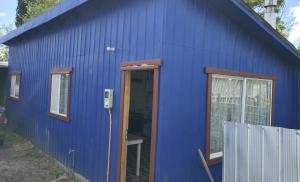 a blue building with a door and windows at departamento el coiron in Cochrane