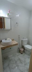 a white bathroom with a toilet and a sink at Apartamento 2 quartos - Em frente a praia in Saquarema +7 photos