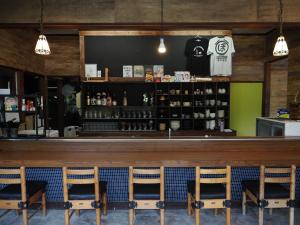 a bar with chairs in front of a counter at 須佐交流型ゲストハウス ぽっとで in Susa