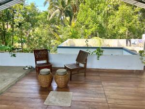 patio con 2 sillas y bañera en Island Retreat Vypin Entire Space, en Kochi