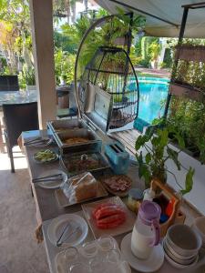 a table with food and a bird cage on it at Monaburi Boutique Resort in Rawai Beach