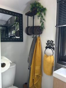 a bathroom with yellow towels and a mirror at Flying Scotsman Unique Carriage Pet Friendly! Lazy Spa can be available upon request with additional cost of 40 in Bridgend