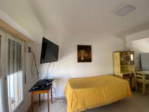 a bedroom with a bed and a television on the wall at Ph Completo Petfriendly in Mar del Plata