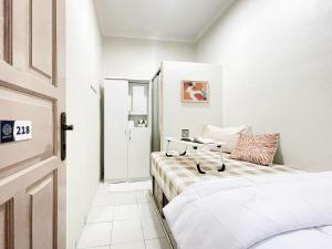 a small bedroom with two beds and a door at Awany CoLiving in Jakarta