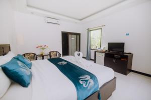 a bedroom with a bed with blue and white sheets at Monaburi Boutique Resort in Rawai Beach