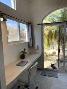 a desk and a chair in a room with a window at Shaka Studio - steps to beach in Punta Mita