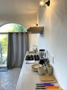 a kitchen with a counter top with plates and a stove at Shaka Studio - steps to beach in Punta Mita