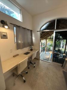 a home office with a desk and a large window at Shaka Studio - steps to beach in Punta Mita +7 photos