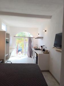 a room with a kitchen with a window and a stove at Shaka Studio - steps to beach in Punta Mita