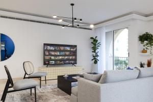 a living room with a couch and a table and chairs at Safi Blues 3 BR Apartment in Beirut