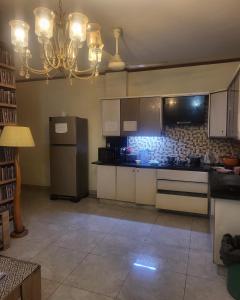 a kitchen with a refrigerator and a stove top oven at Seaview Residency in Karachi