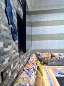 a living room with a couch against a brick wall at Appartement très calme a 10 mn de mehdia in Kenitra
