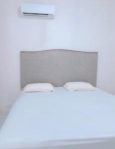 a white bed with two pillows on top of it at Loft teba near Tapachula airport in Tapachula