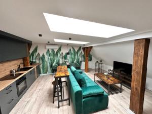 a living room with a green couch and a table at KOBIELA Luxury LOFT City Center in Katowice