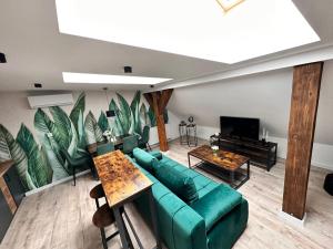 a living room with a green couch and a tv at KOBIELA Luxury LOFT City Center in Katowice