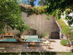 Un patio con mesa y sillas y una piscina. en Mas de silvacane, en La Roque-d'Anthéron