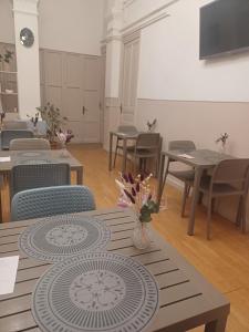 a dining room with tables and chairs and a television at Albergo Malibu in Sanremo