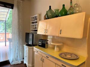 eine Küche mit grünen Glasvasen auf einer Theke in der Unterkunft Il Piccolo Giardino Paratico in Paratico