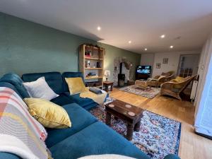 a living room with a blue couch and a table at Dene Cottage - Perfect for 8 & Pets in Youlgrave - Pass the Keys in Youlgreave