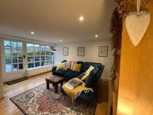 a living room with a green couch and a table at Dene Cottage - Perfect for 8 & Pets in Youlgrave - Pass the Keys in Youlgreave