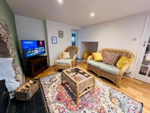 a living room with a couch and a tv at Dene Cottage - Perfect for 8 & Pets in Youlgrave - Pass the Keys in Youlgreave