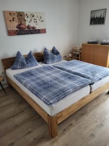 a bedroom with a bed with a blue plaid blanket at Ferienwohnung in Hameln am Wald in Hameln
