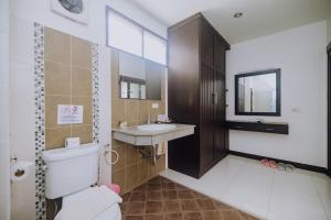 a bathroom with a toilet and a sink and a mirror at Monaburi Boutique Resort in Rawai Beach