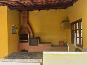 an outdoor room with a brick oven in a house at Recanto Sol Maior - Casa Girassol in Sapucaí-Mirim +27 photos