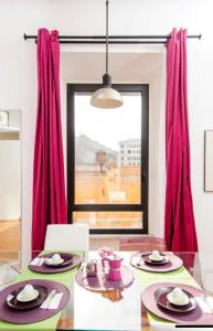 a dining room with a glass table and red curtains at LoL-ApartmenT, in the heart of Trastevere in Rome