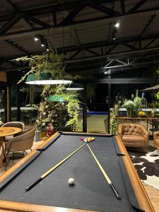 a pool table with two cuesticks on top of it at Celeiro Lake Village in São Francisco de Paula