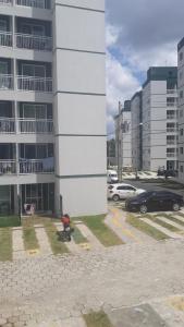 a building with cars parked in a parking lot at Hospedagem COP30 in Ananindeua