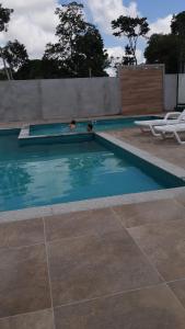 a couple of people in a swimming pool at Hospedagem COP30 in Ananindeua