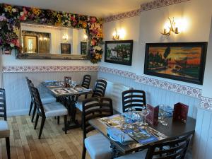 a restaurant with two tables and chairs and a mirror at The Crags Hotel in Callander