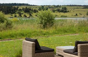 two wicker chairs and a table in a field at instants d'Absolu Ecolodge & Spa in La Boissonnière +28 photos