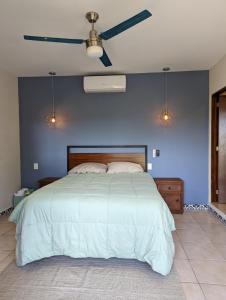 a bedroom with a large bed with a blue wall at Stunning 2BR, with outdoor living space and ocean view in Sayulita