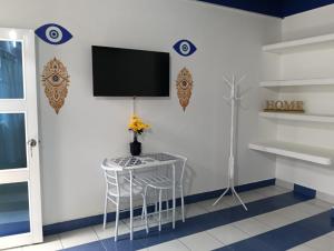 a room with a table and a tv on a wall at Casa Skyros in Arboletes