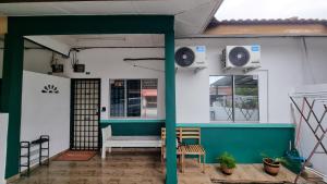 a porch of a house with a green and white wall at MAR Homestay Seri Iskandar in Seri Iskandar