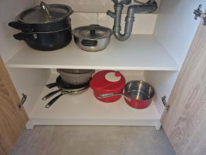 a kitchen shelf with pots and pans and a sink at Joli studio in Saint-Raphaël
