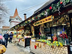 a market with people and a dog in front of a building at 5 to Stay near Legends of Bran in Bran
